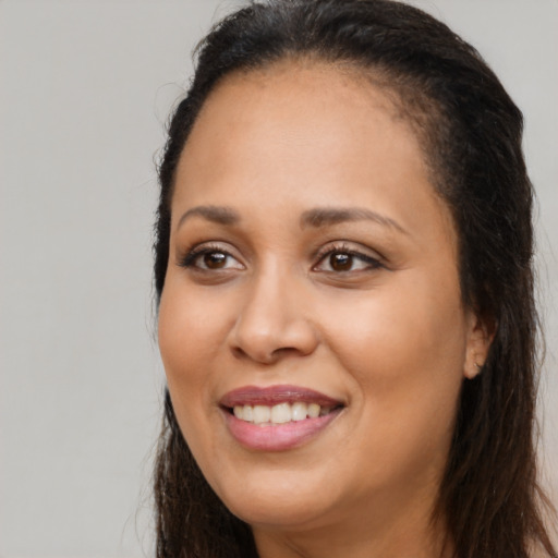 Joyful black young-adult female with long  brown hair and brown eyes