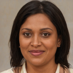 Joyful black adult female with medium  brown hair and brown eyes