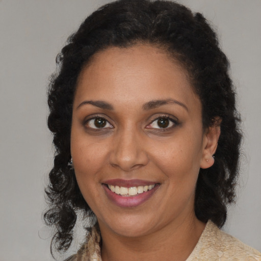 Joyful black young-adult female with medium  brown hair and brown eyes