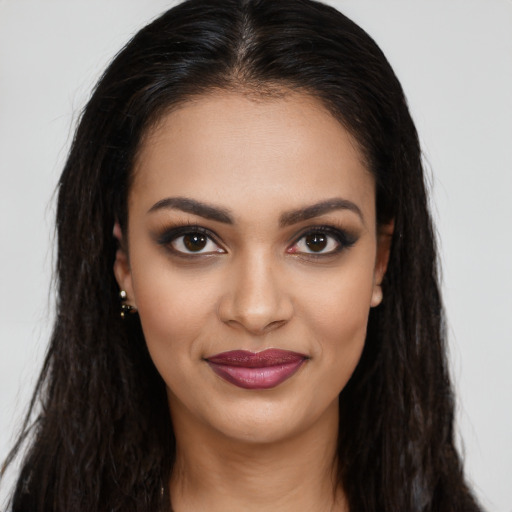 Joyful latino young-adult female with long  brown hair and brown eyes