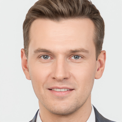 Joyful white young-adult male with short  brown hair and grey eyes