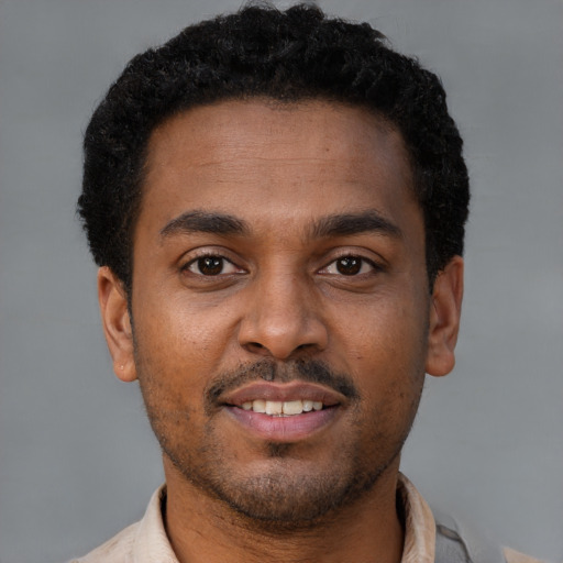 Joyful latino young-adult male with short  brown hair and brown eyes