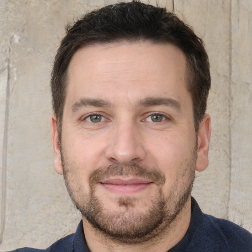 Joyful white young-adult male with short  brown hair and brown eyes