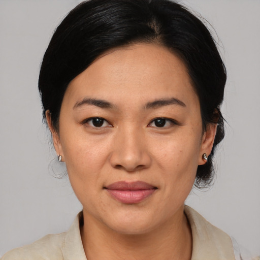 Joyful asian adult female with medium  brown hair and brown eyes