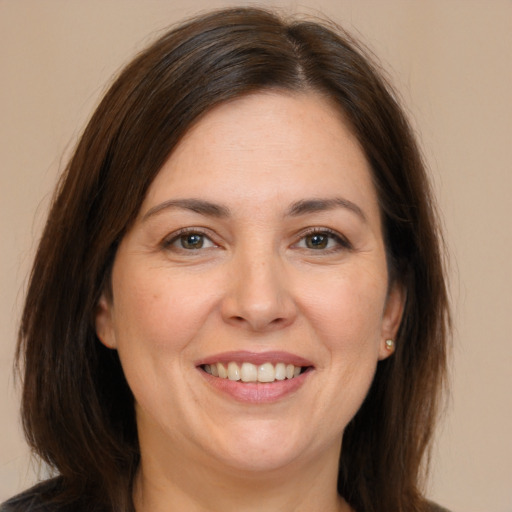 Joyful white adult female with long  brown hair and brown eyes