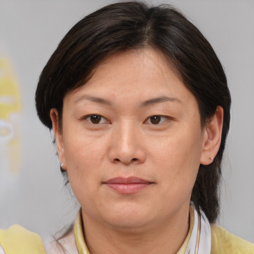 Joyful asian adult female with medium  brown hair and brown eyes