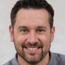 Joyful white adult male with short  brown hair and brown eyes