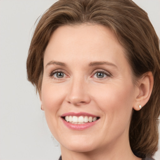 Joyful white young-adult female with medium  brown hair and green eyes