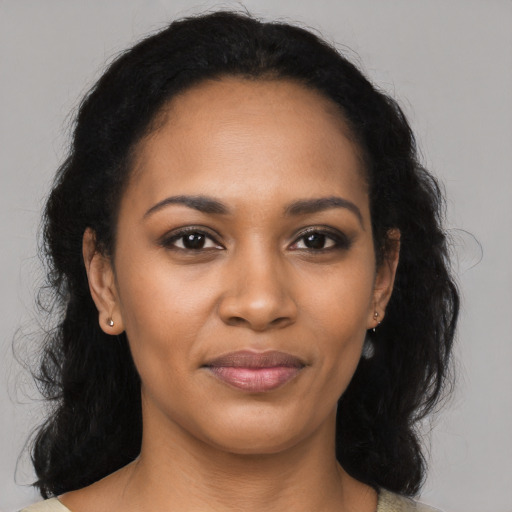 Joyful black young-adult female with long  black hair and brown eyes