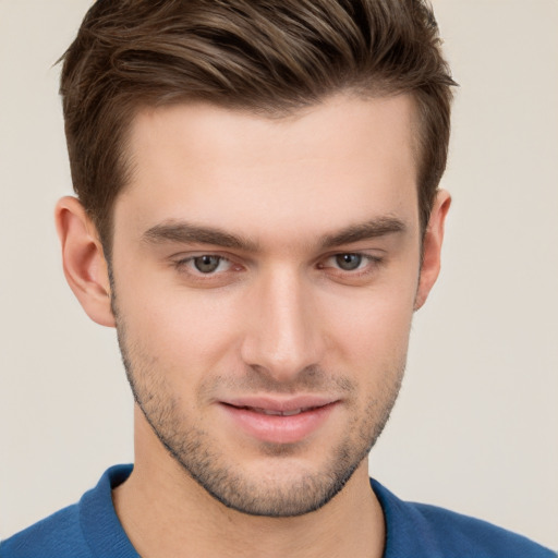 Joyful white young-adult male with short  brown hair and grey eyes