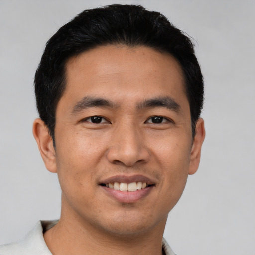 Joyful asian young-adult male with short  black hair and brown eyes