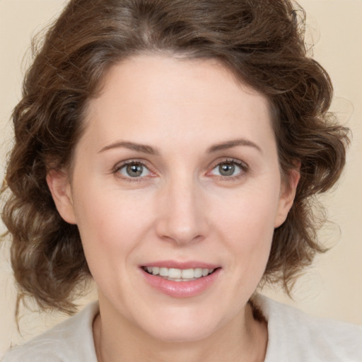 Joyful white young-adult female with medium  brown hair and green eyes