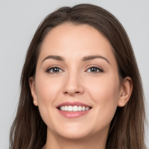 Joyful white young-adult female with long  brown hair and brown eyes