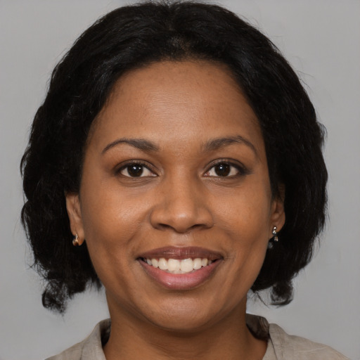 Joyful black adult female with medium  brown hair and brown eyes
