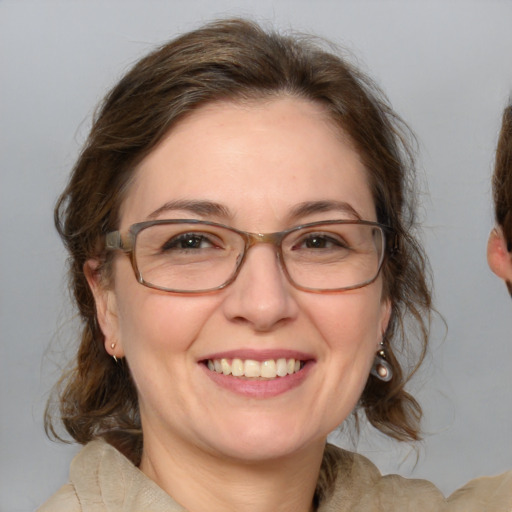 Joyful white adult female with medium  brown hair and blue eyes