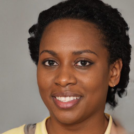Joyful black young-adult female with short  black hair and brown eyes