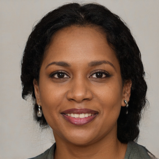 Joyful black young-adult female with medium  brown hair and brown eyes