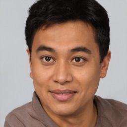 Joyful asian young-adult male with short  brown hair and brown eyes