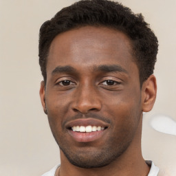 Joyful black young-adult male with short  brown hair and brown eyes