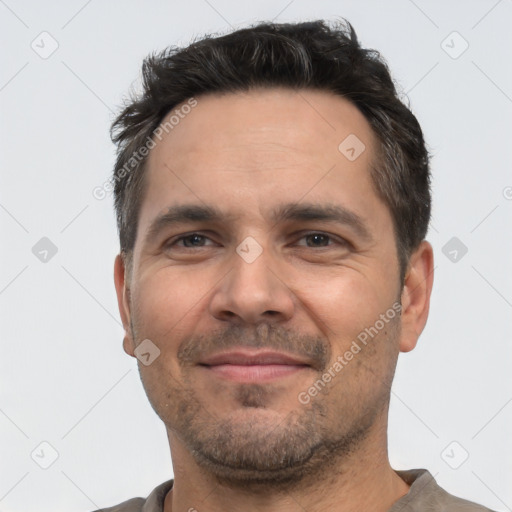 Joyful white adult male with short  black hair and brown eyes