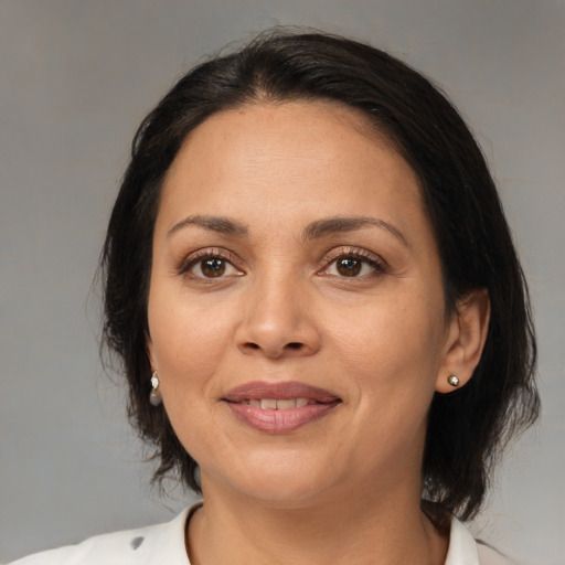 Joyful latino adult female with medium  brown hair and brown eyes