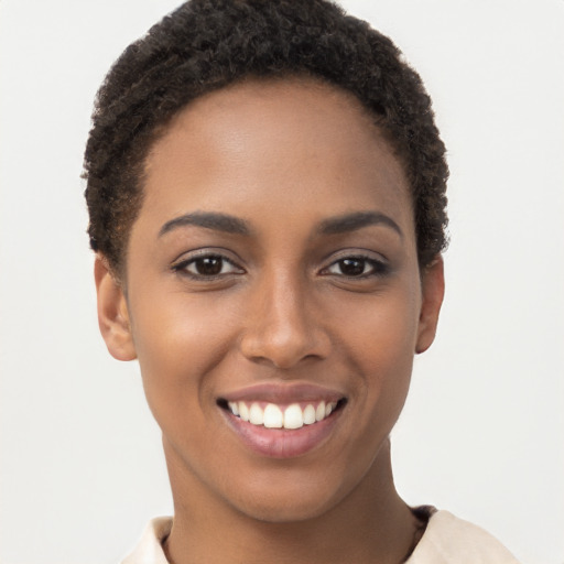 Joyful black young-adult female with short  brown hair and brown eyes