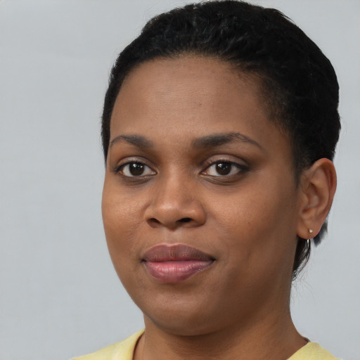 Joyful black young-adult female with short  black hair and brown eyes
