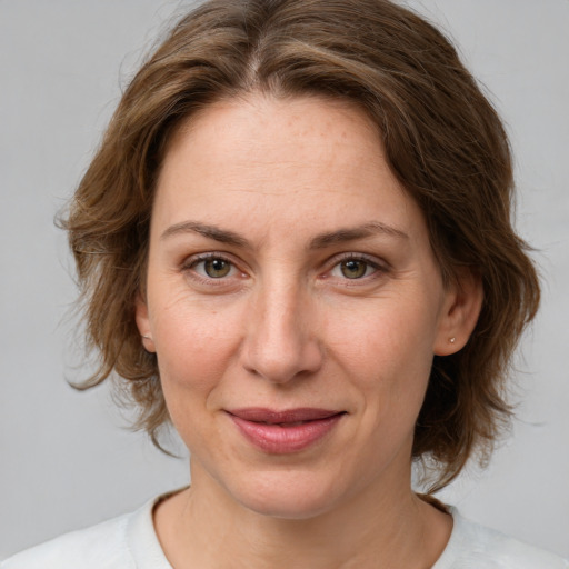 Joyful white adult female with medium  brown hair and grey eyes