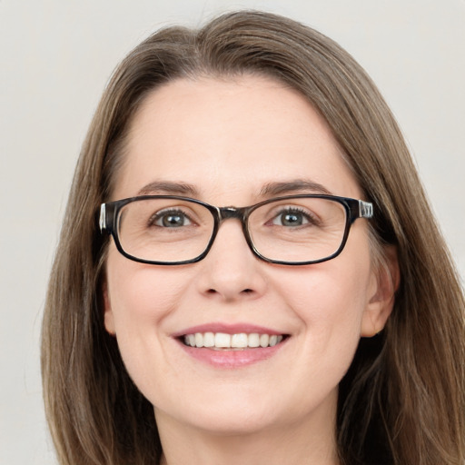 Joyful white adult female with long  brown hair and green eyes