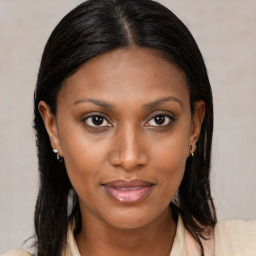 Joyful black young-adult female with long  brown hair and brown eyes