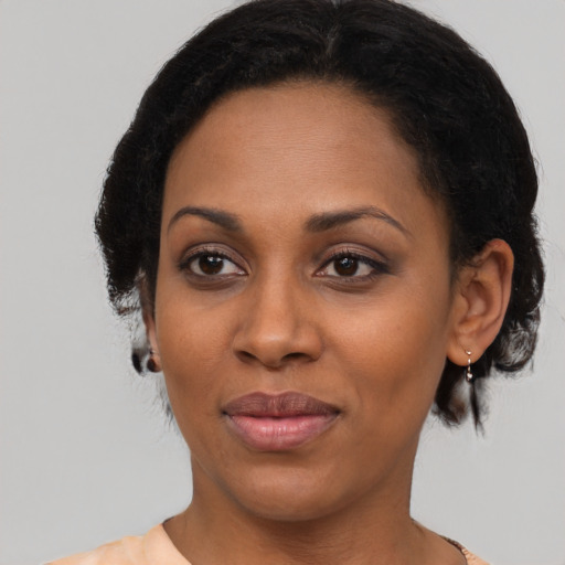 Joyful black adult female with medium  brown hair and brown eyes