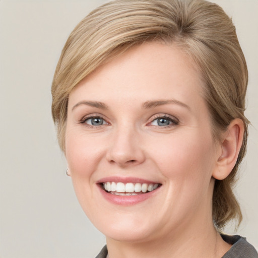 Joyful white young-adult female with medium  brown hair and blue eyes