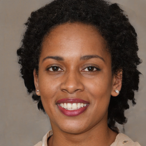 Joyful black young-adult female with medium  brown hair and brown eyes