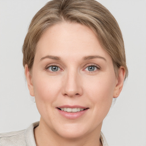 Joyful white young-adult female with medium  brown hair and blue eyes