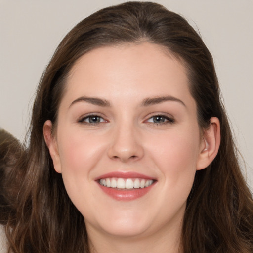 Joyful white young-adult female with long  brown hair and grey eyes