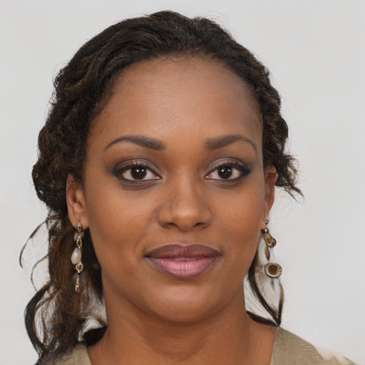 Joyful black young-adult female with long  brown hair and brown eyes