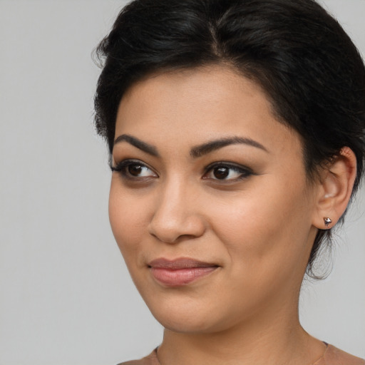 Joyful latino young-adult female with medium  black hair and brown eyes