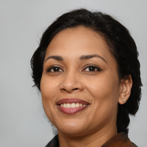 Joyful latino adult female with medium  brown hair and brown eyes