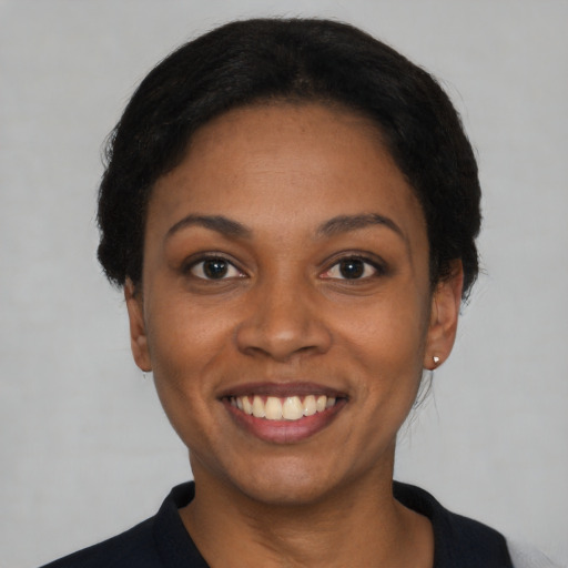 Joyful black young-adult female with short  black hair and brown eyes
