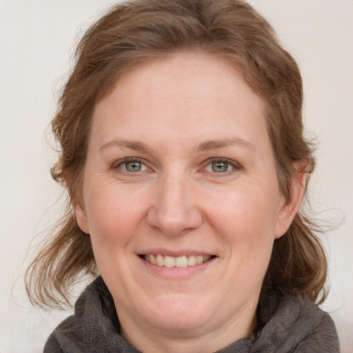 Joyful white adult female with medium  brown hair and blue eyes