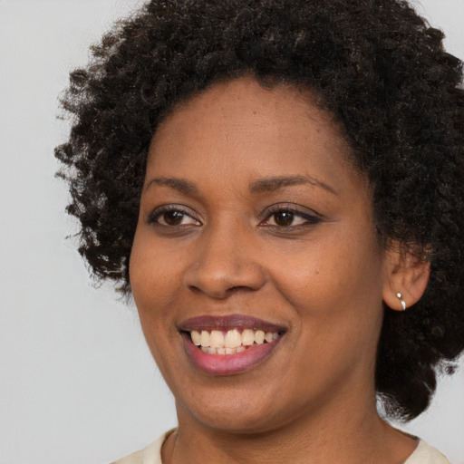 Joyful black young-adult female with medium  brown hair and brown eyes