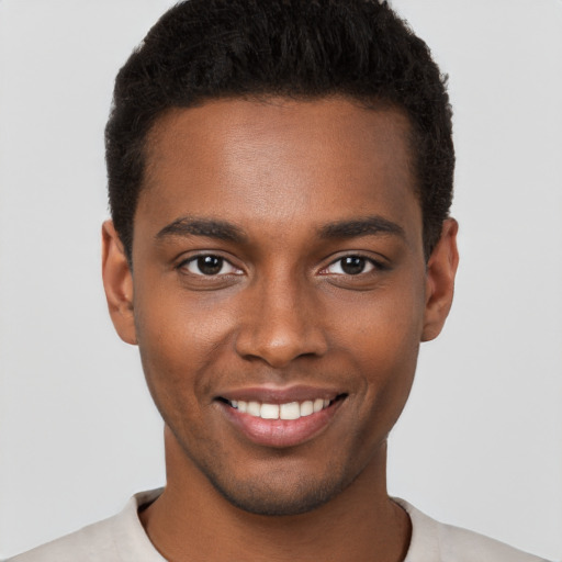 Joyful black young-adult male with short  brown hair and brown eyes