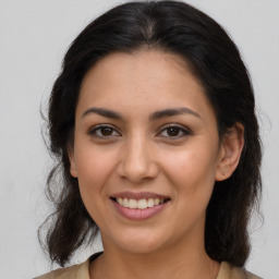 Joyful latino young-adult female with medium  brown hair and brown eyes