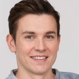 Joyful white young-adult male with short  brown hair and grey eyes