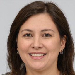 Joyful white adult female with long  brown hair and brown eyes