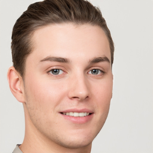 Joyful white young-adult male with short  brown hair and grey eyes