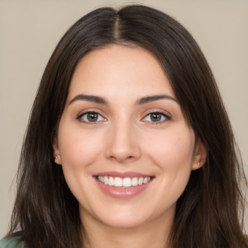 Joyful white young-adult female with long  brown hair and brown eyes