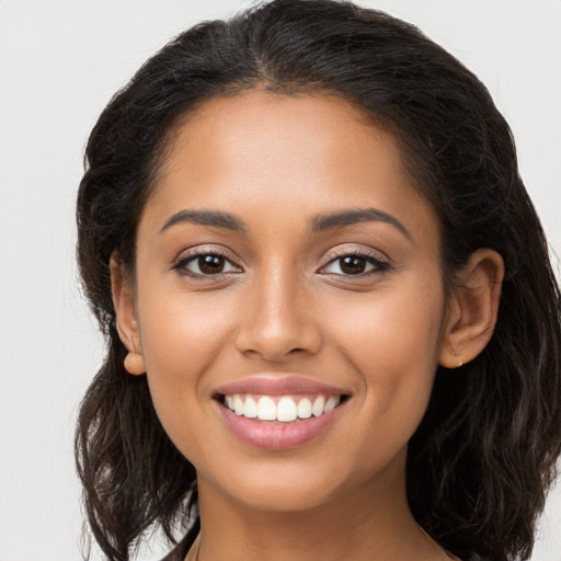 Joyful latino young-adult female with long  brown hair and brown eyes