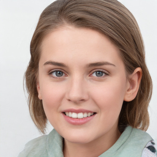 Joyful white young-adult female with medium  brown hair and blue eyes