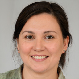 Joyful white young-adult female with medium  brown hair and grey eyes